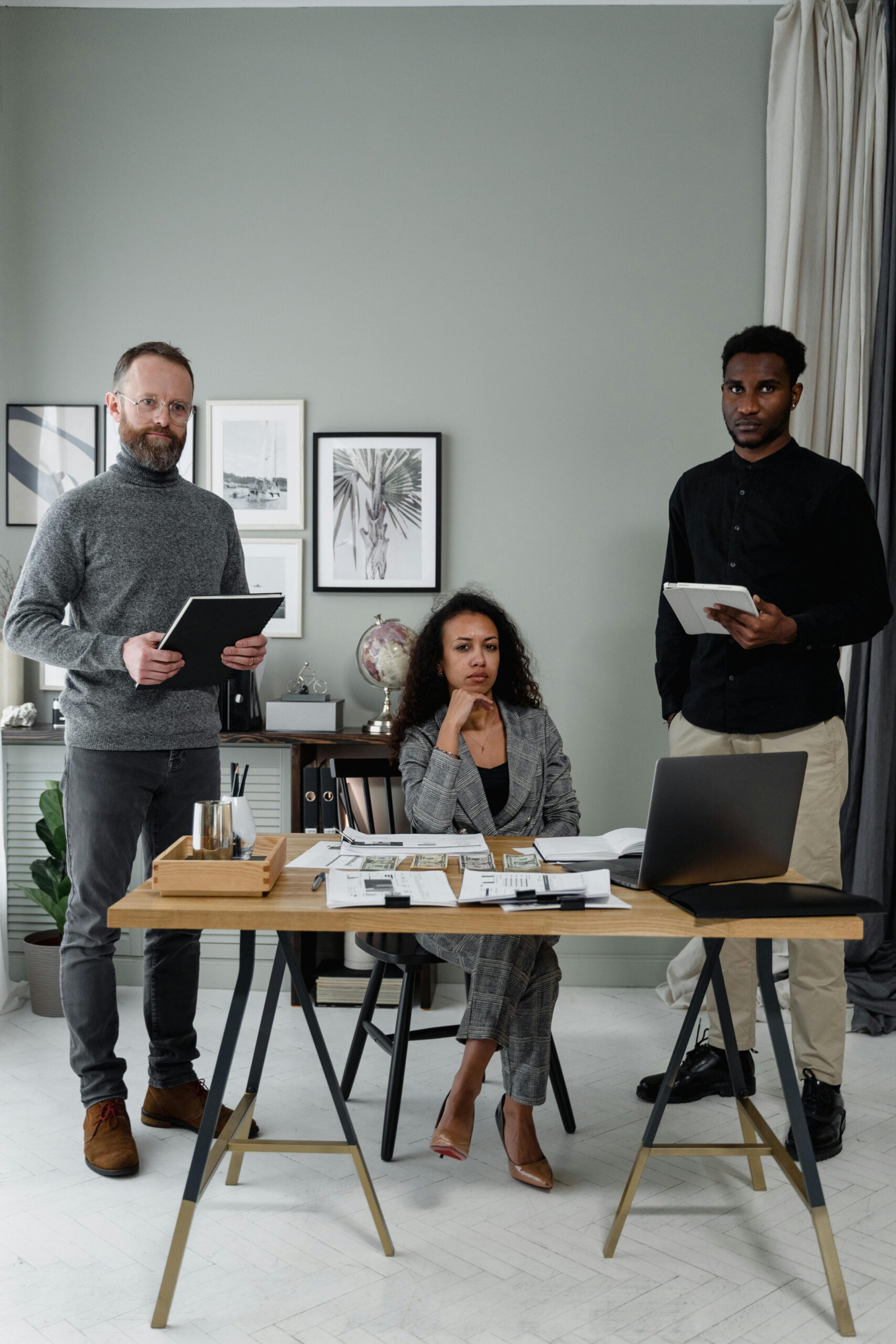 Business team working together in a stylish office setting with tablets and laptops.